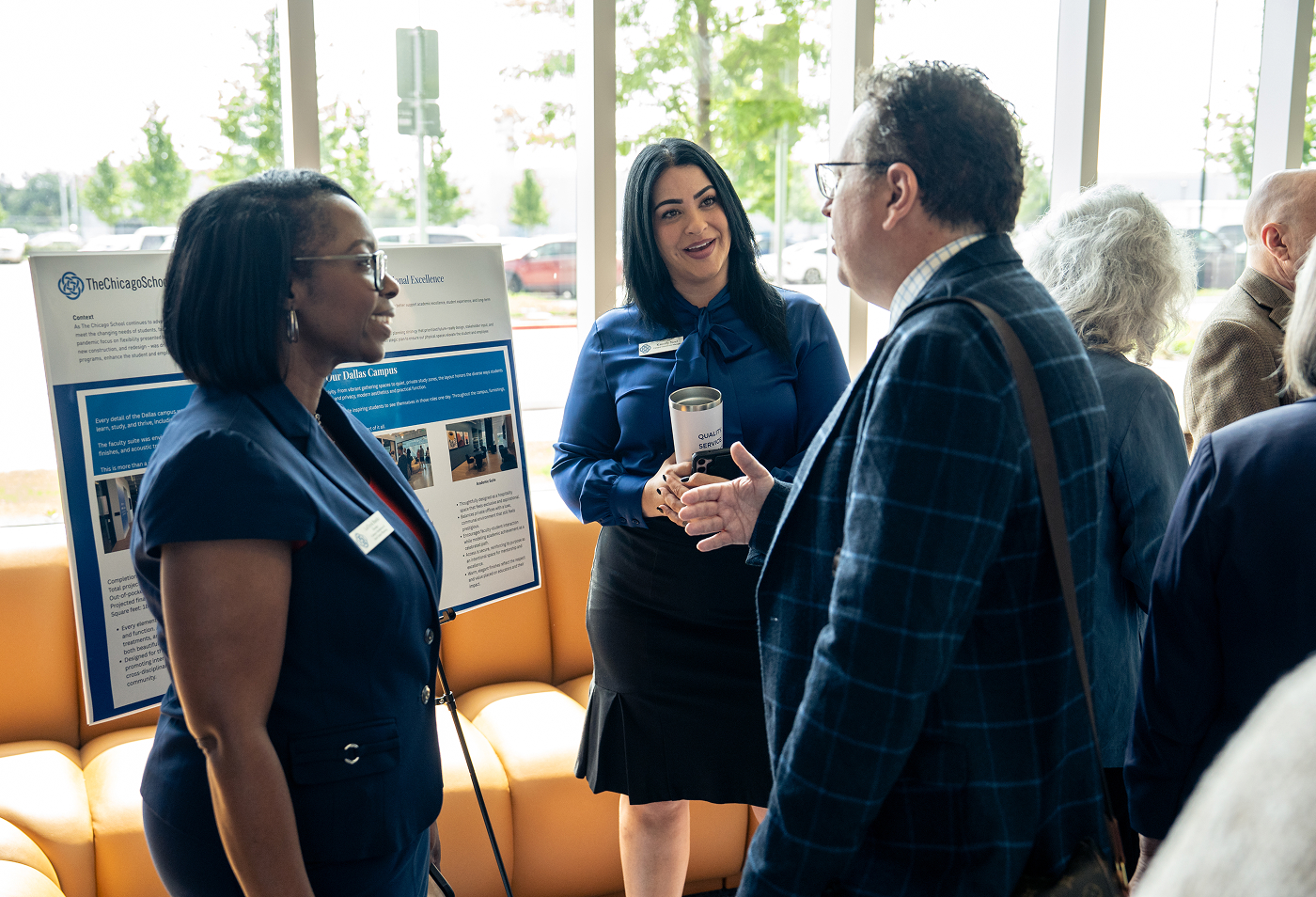 A group of two people discussing a presentation on a board with another person.