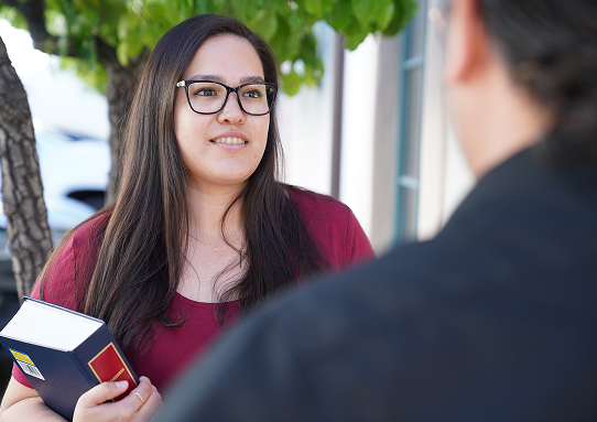 woman with glasses holding a book