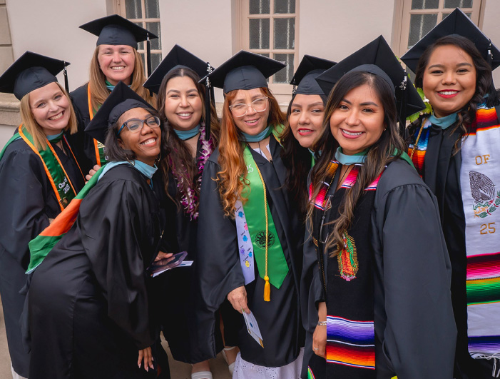 red haired woman holding son with graduation cap on